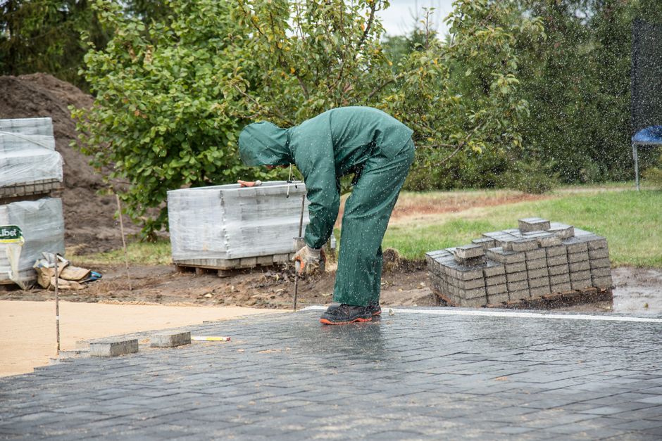 Worker laying paving stones outdoors